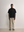 Standing model styling the black Kyneton Relaxed Fit Knit Polo A.B.C A BRAND COLLECTIVE boxy fit silhouette