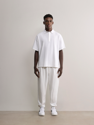 Model wearing the white Kyneton Relaxed Fit Knit Polo A.B.C A BRAND COLLECTIVE modern boxy silhouette