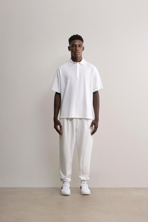 Model wearing the white Kyneton Relaxed Fit Knit Polo A.B.C A BRAND COLLECTIVE modern boxy silhouette