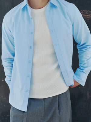 Detailed texture of the white Windsor Waffle Knit Tee A.B.C A BRAND COLLECTIVE under a light blue shirt.