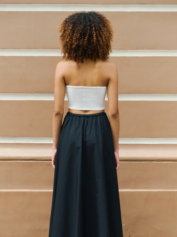 Modern aesthetic from behind featuring the white Preston top and a contrasting black maxi skirt.
