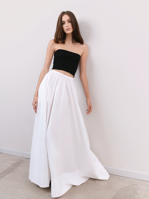 Stylish model wearing a black midi bandeau paired with a white high waisted skirt for a confident modern aesthetic.