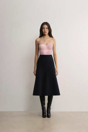 Model pairing the pink A.B.C A BRAND COLLECTIVE bustier with a black skirt for an elegant contrast.