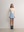 Model styling the blue A.B.C A BRAND COLLECTIVE mini skirt with a cream turtleneck