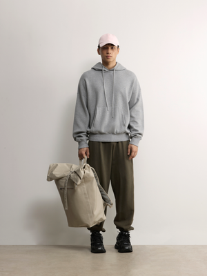 A.B.C A BRAND COLLECTIVE Kyneton Hoodie male model styling the grey knit with olive trousers and a travel bag 100% Good Earth Cotton