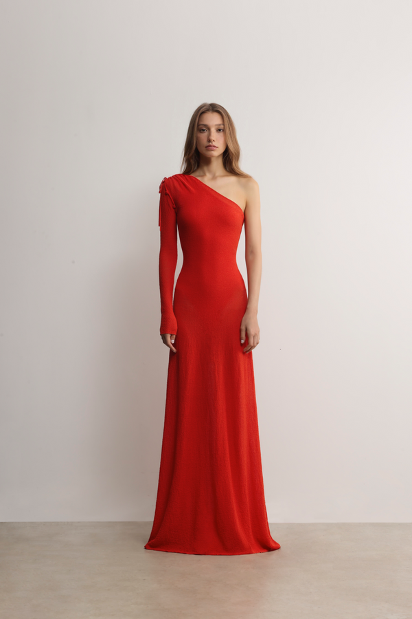 Model in A.B.C A BRAND COLLECTIVE red gown; showcasing the sleek viscose-nylon blend and elegant asymmetrical silhouette.