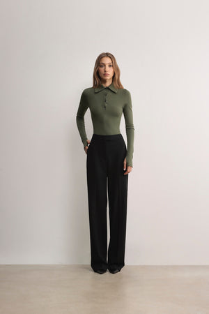 Model wearing green Alma bodysuit by A.B.C A BRAND COLLECTIVE, balanced between structure and stretch for a clean everyday look.