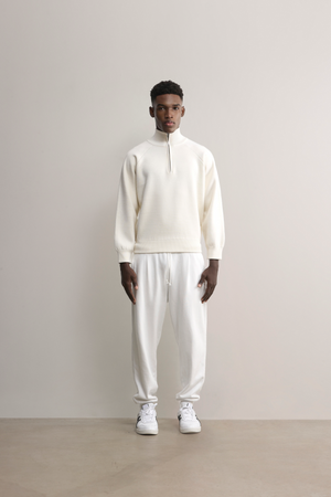 Model in cream Glenorchy knit polo by ABrandCollective, relaxed fit with warmth and breathability from layered wool.