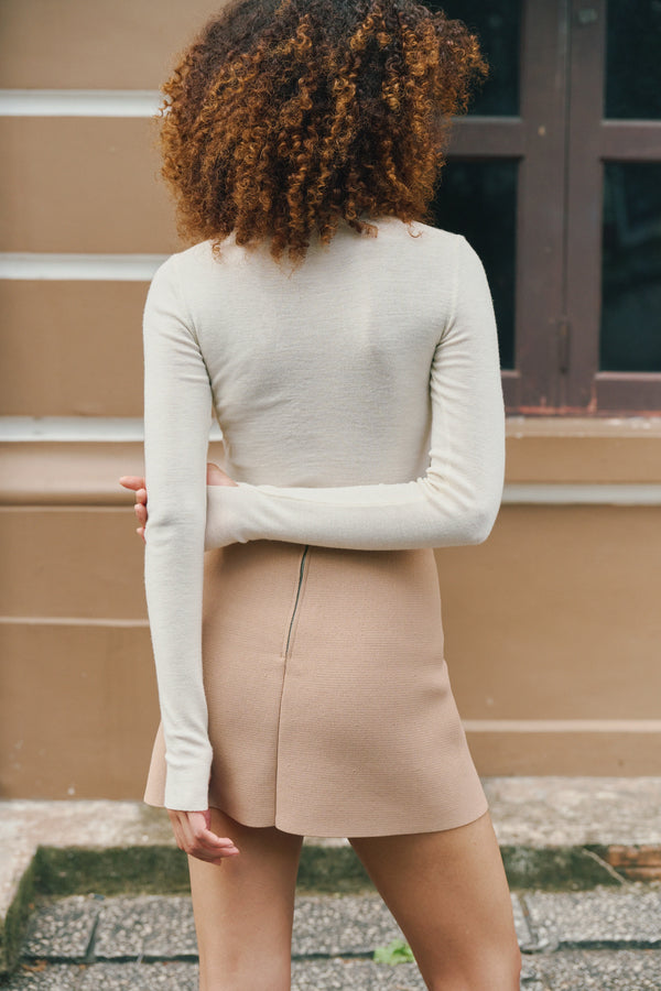 Back view of the ivory Mona Full Needle Rib Merino Wool Turtle Neck Top A.B.C A BRAND COLLECTIVE durable layering versatility