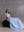 Seated model in blue MOREE dress by A.B.C A BRAND COLLECTIVE, fabric falls naturally, giving a soft and easy silhouette.