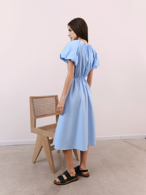 Rear view of A.B.C A BRAND COLLECTIVE blue dress highlighting its effortless drape and structured, lightweight cotton fabric.