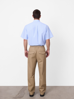 Close up of a neat elastic waistband and functional side hand pockets on relaxed beige trousers by A.B.C A BRAND COLLECTIVE